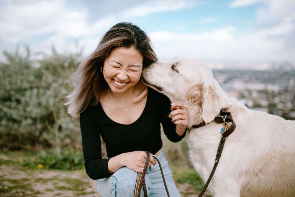 Happy resident with dog at Castle Hill Apartments in Sacramento, California